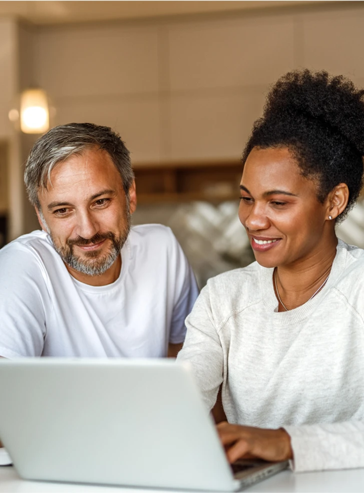 A man and women looking at a laptop together