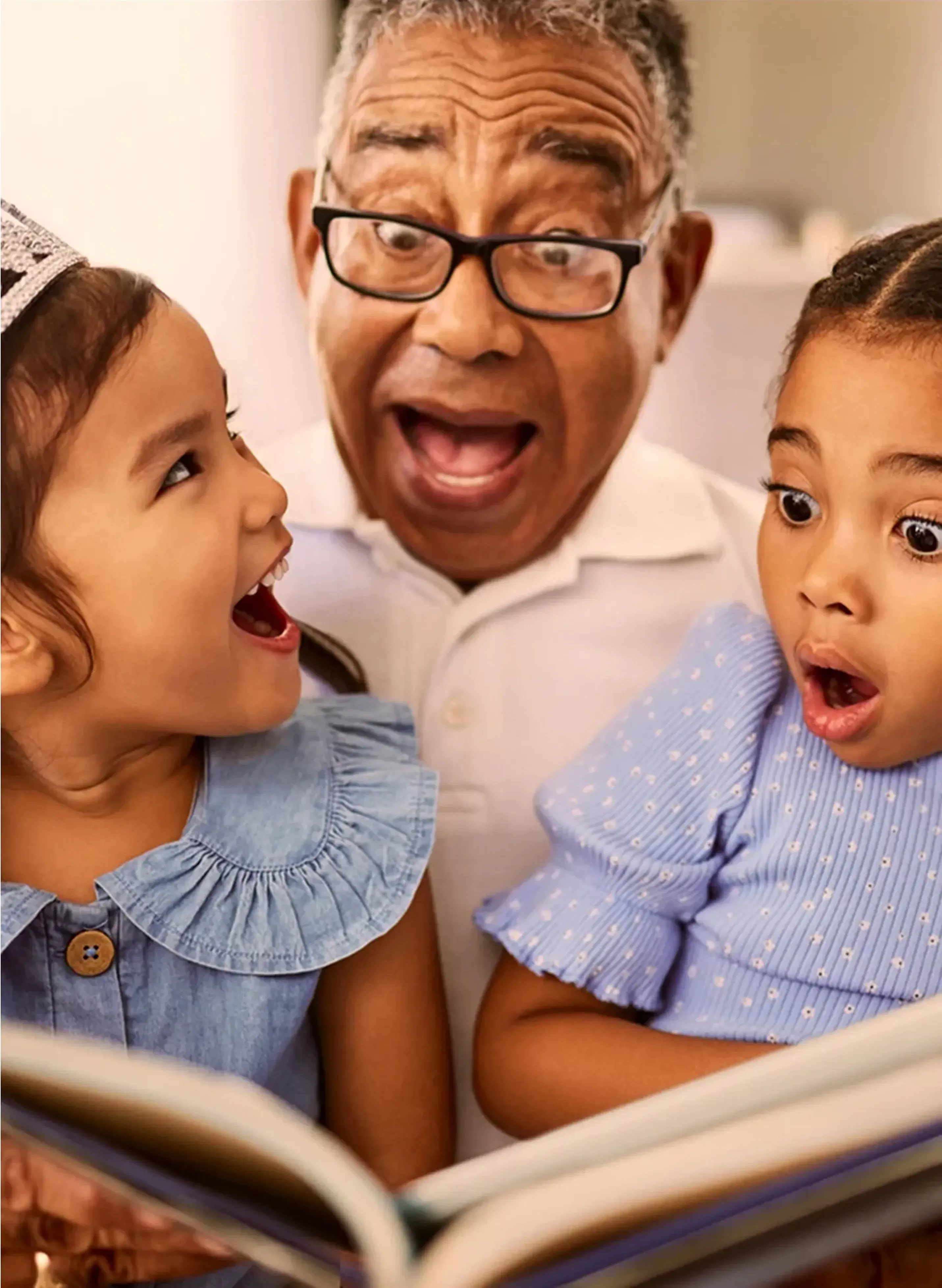 Grandfather reading a book to his children
