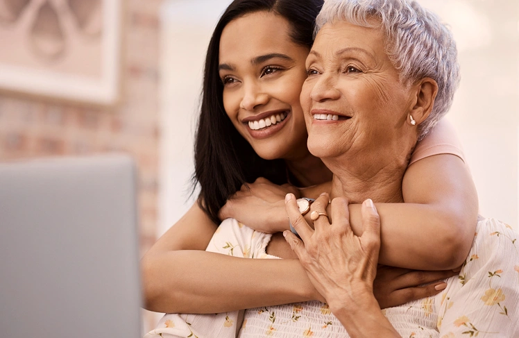 A mom and daughter hugging and smiling